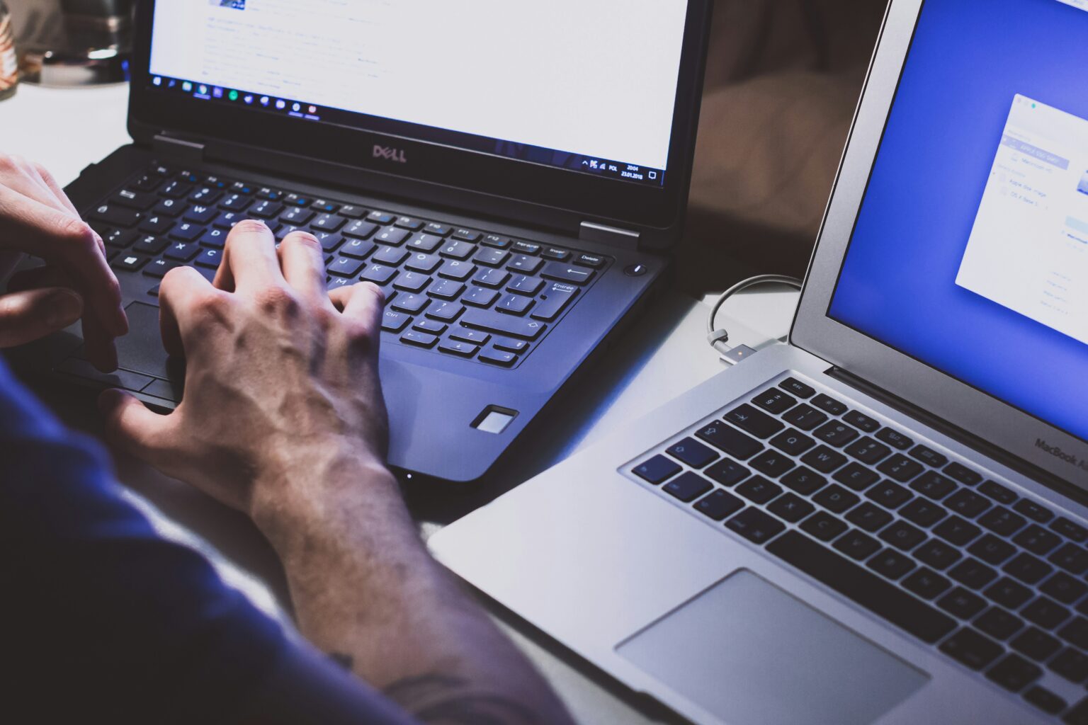 Man sitter med två laptops